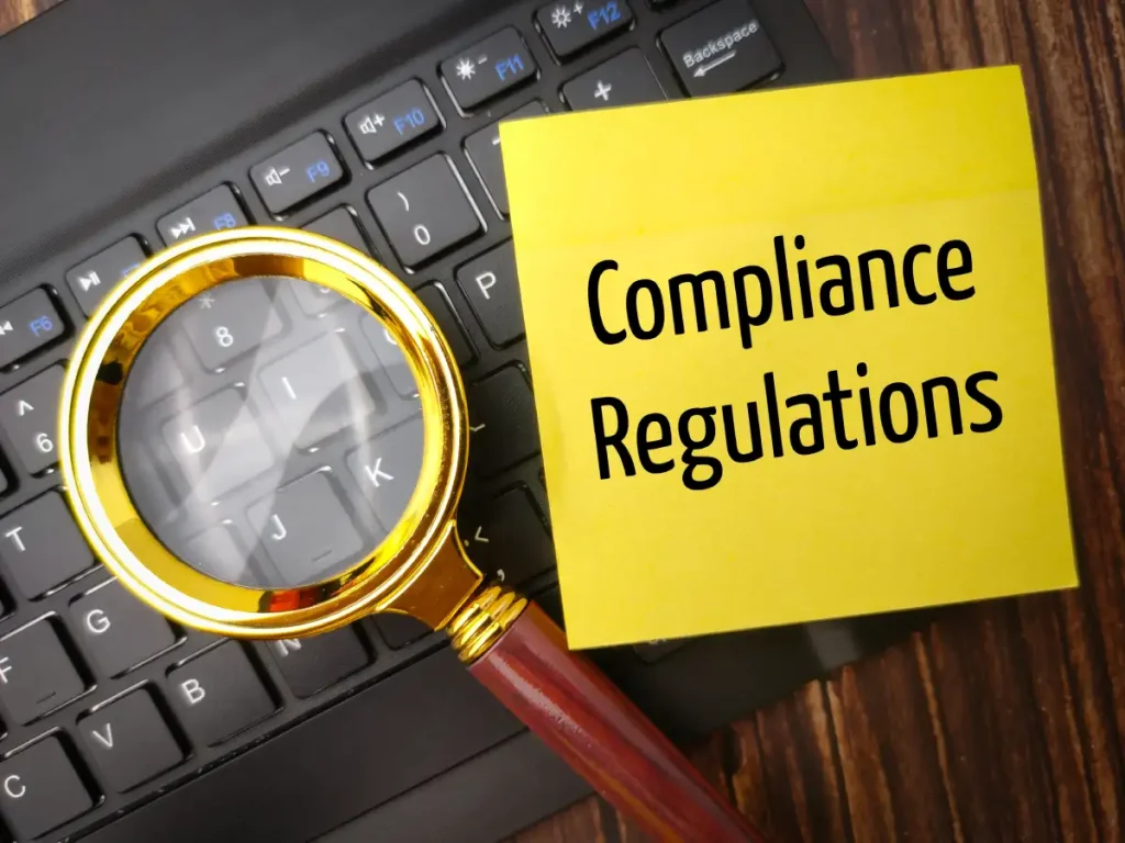 top view magnifying glass wireless keyboard with word compliance regulations depicting Regulations in Clinical Trials